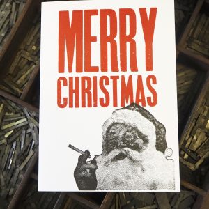 Bad Santa - Letterpress Christmas Card. Hand printed in bright red and black, using original letterpress type. The card shows an image of Santa Claus smoking a cigarette.